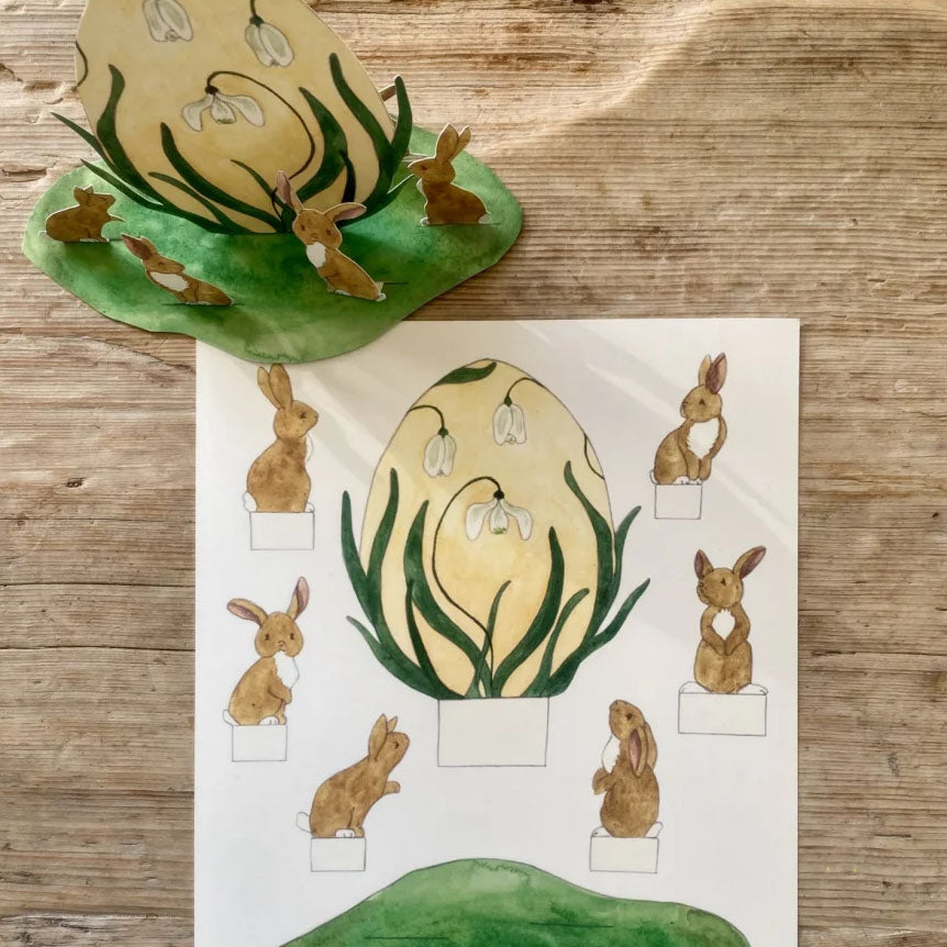 Snøklokke-egg med harer omkring