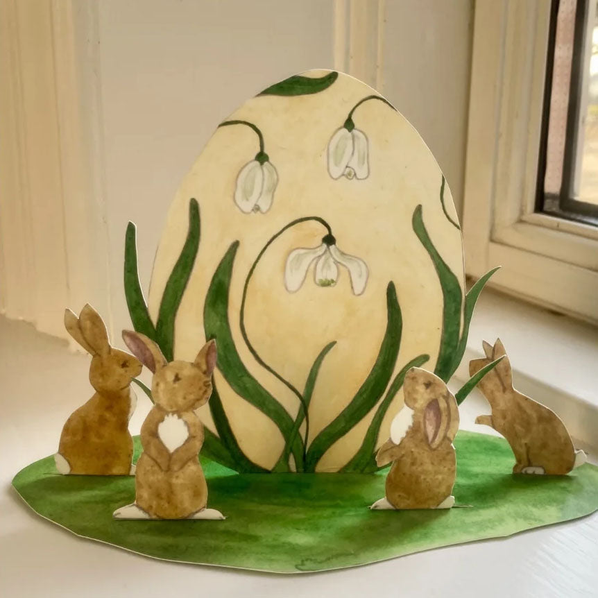 Snøklokke-egg med harer omkring
